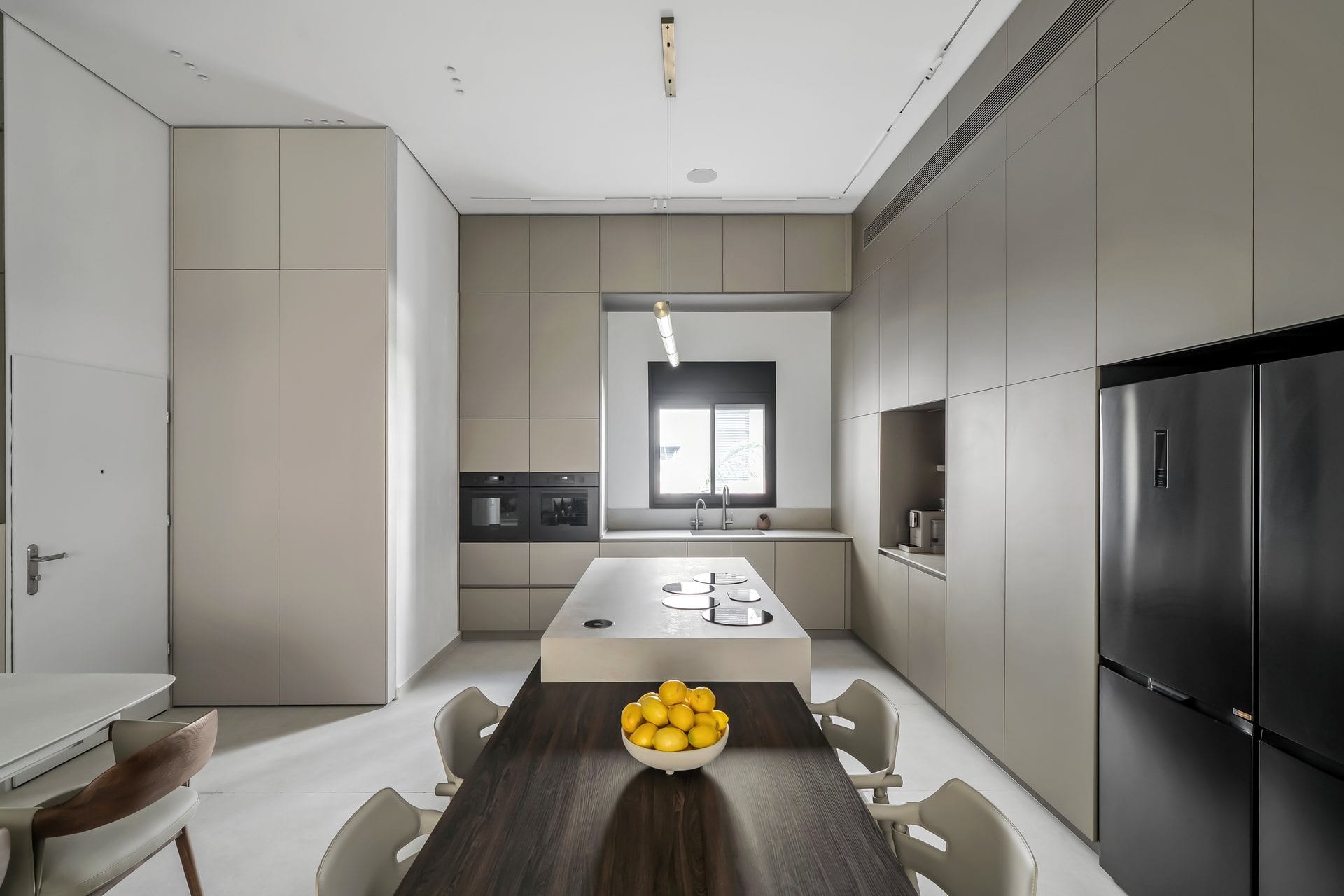 five-minimalist-greige-kitchen-04 מבט לאורך המטבח, נגרות גבוהה משני צדי החלל