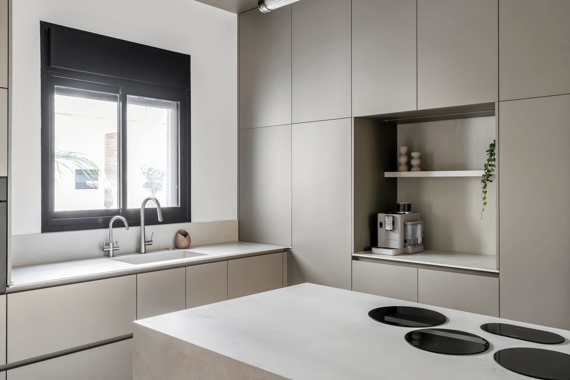 five-minimalist-greige-kitchen-07 משטח העבודה עם הכיור, מול האי ובו הכיריים המשולבות
