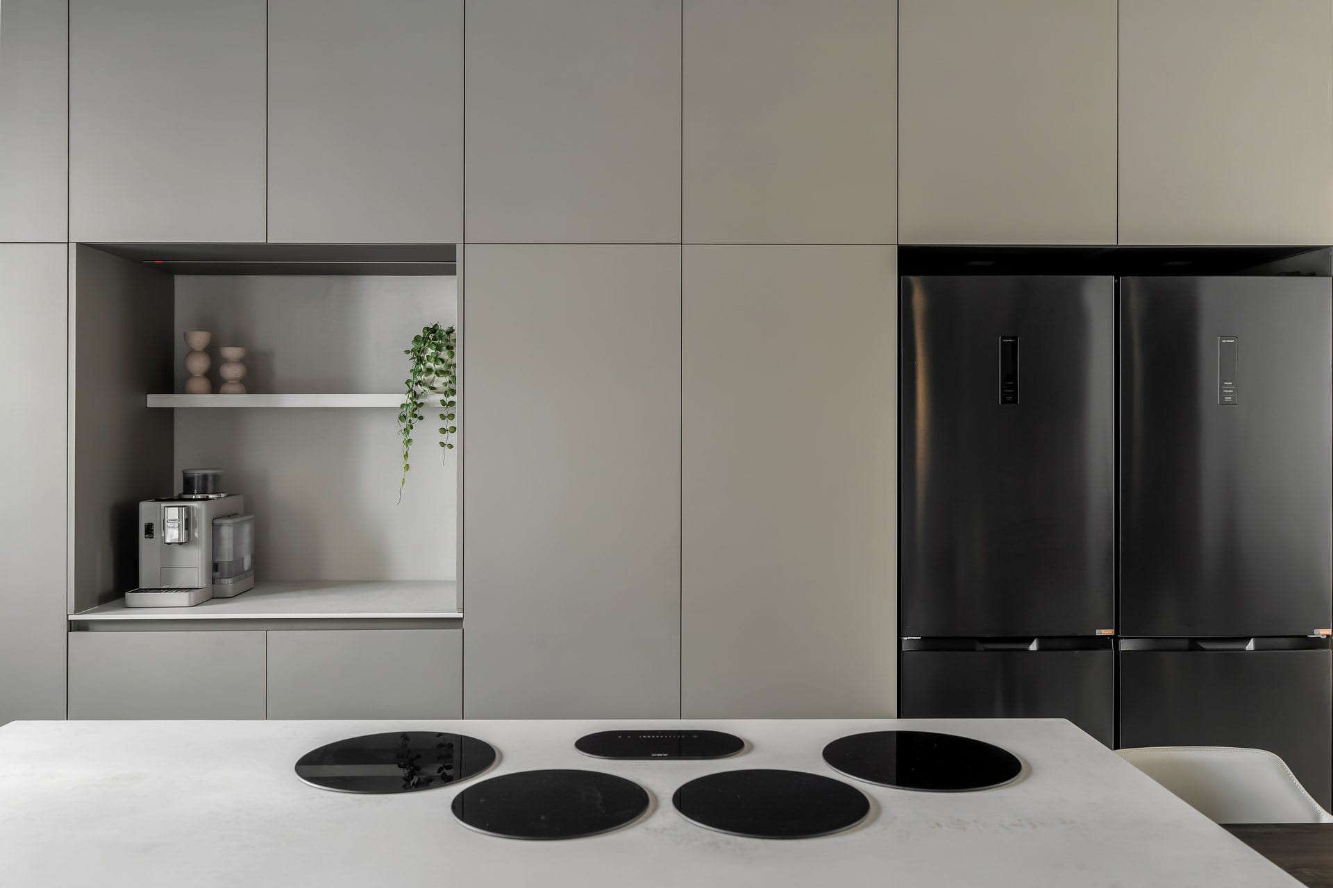 five-minimalist-greige-kitchen-09 הנגרות הגבוהה בגוון בהיר לצד המקרר בגימור שחור